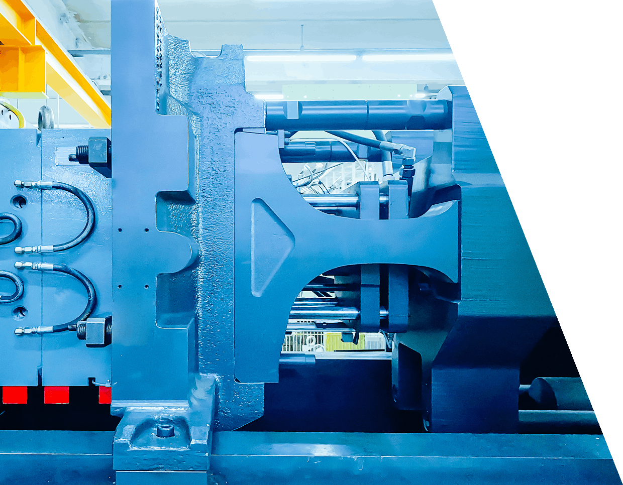 jpeg-optimizer_GettyImages-1407133291 (2) Close-up of a large industrial machine with metal components and hydraulic lines in a factory setting. The machine is mounted on a heavy-duty base.