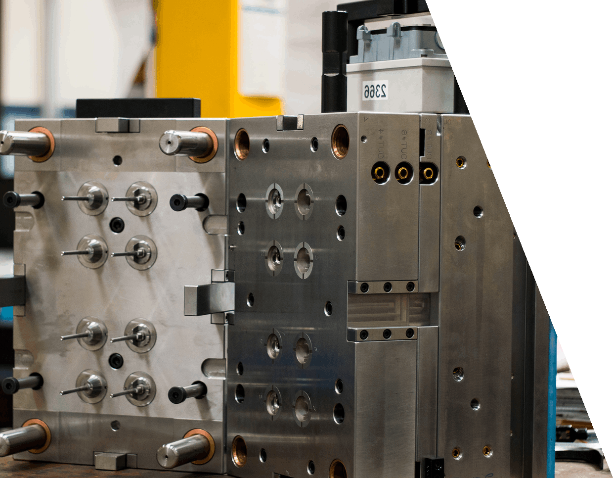 jpeg-optimizer_GettyImages-1407133291 (4) A metal injection mold with multiple pins and components, partially opened, showing intricate parts and mechanical details in an industrial setting.